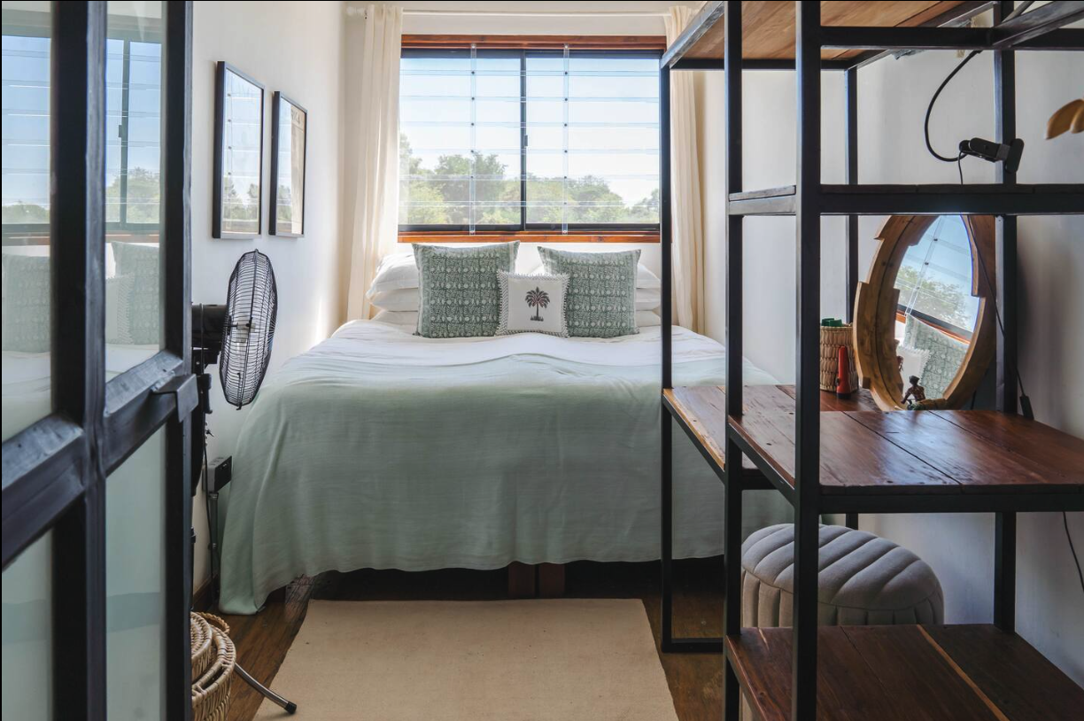 Second bedroom with green linens and large window