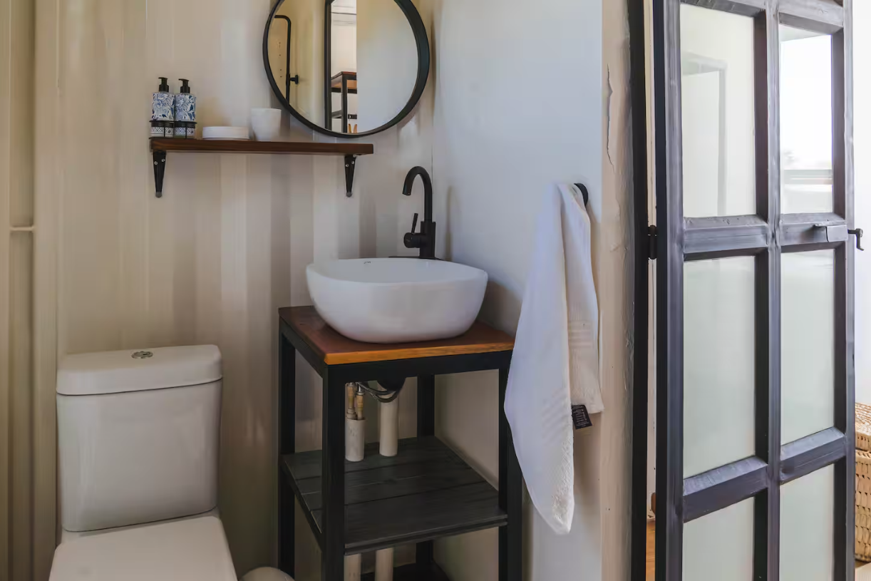 Ensuite bathroom with vessel sink and round mirror
