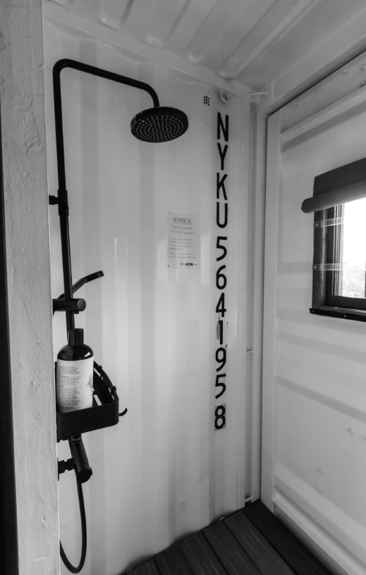 Container shower with original shipping container markings