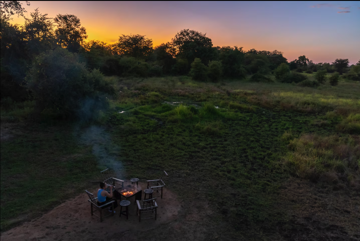 Firepit in the bush with a glowing Luangwa sunset