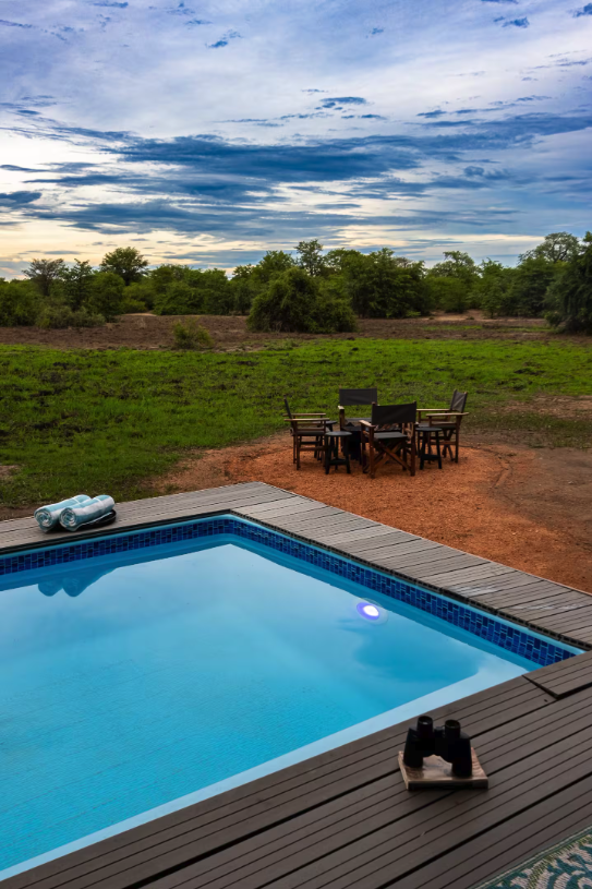 Wide pool view with open sky and campfire seating