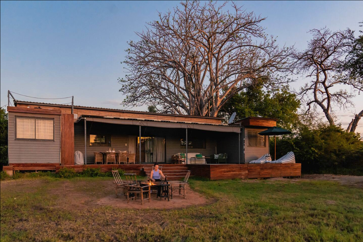 Full exterior of The Bush Box at dusk with firepit in front