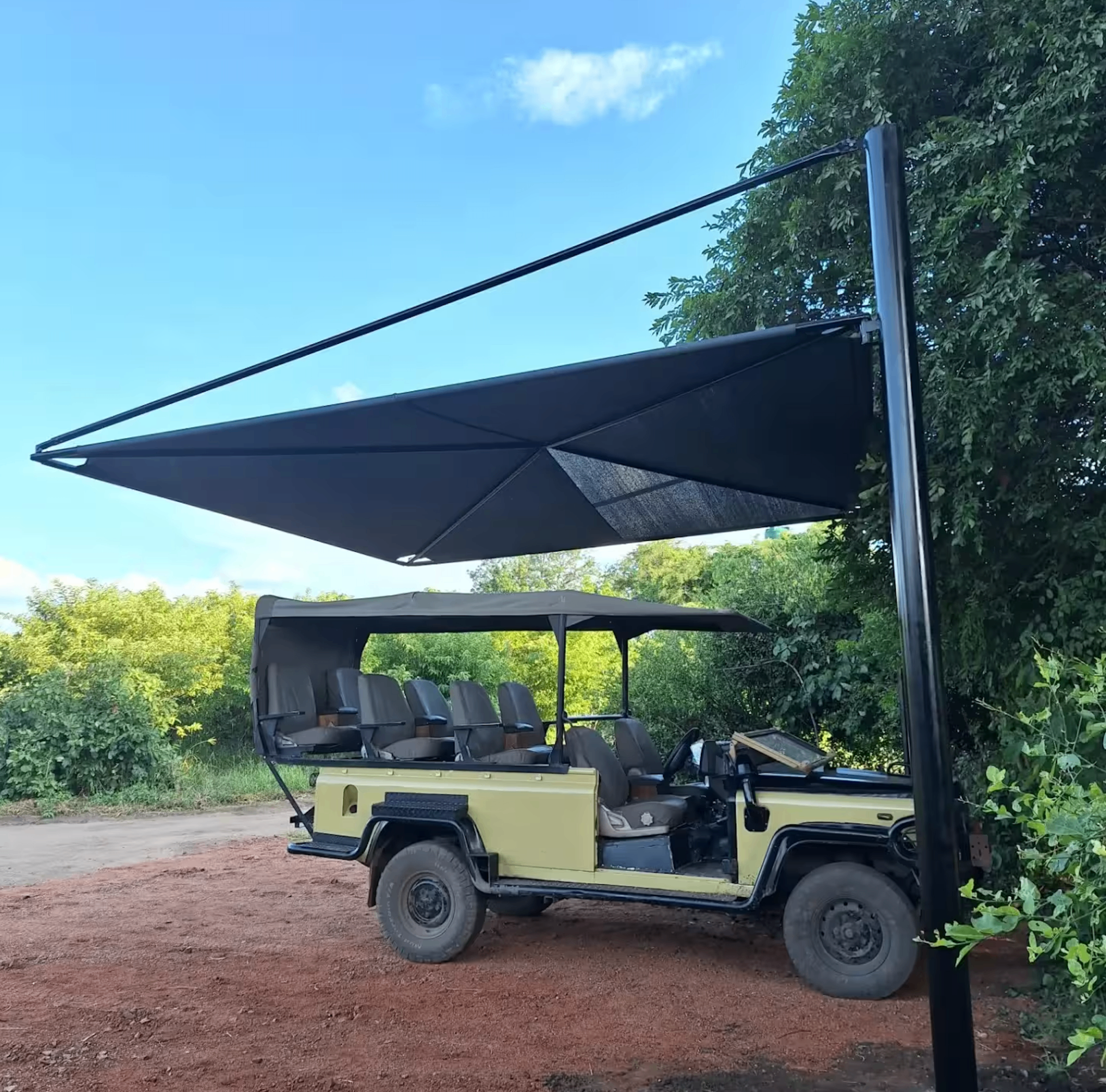 Open safari game drive vehicle parked under a shade sail, ready for a guided game drive