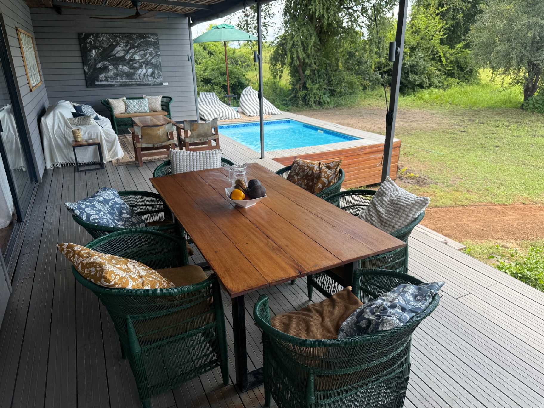 Outdoor dining table on the deck with pool and bush view